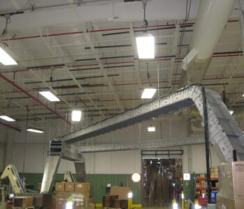 An overhead conveyor system installed in the rafters of a manufacturing warehouse