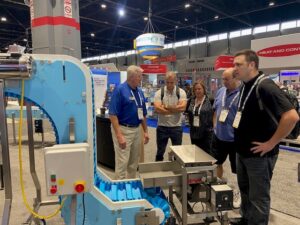 Showing the features of a dynaclean food grade conveyor to packexpo attendees