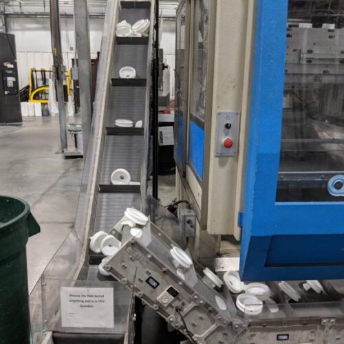 incline conveyor carrying plastic parts