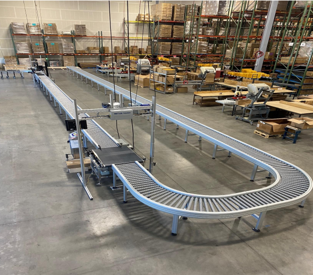 A DynaRoller powered roller conveyor with 90 degree turns in a fulfillment center