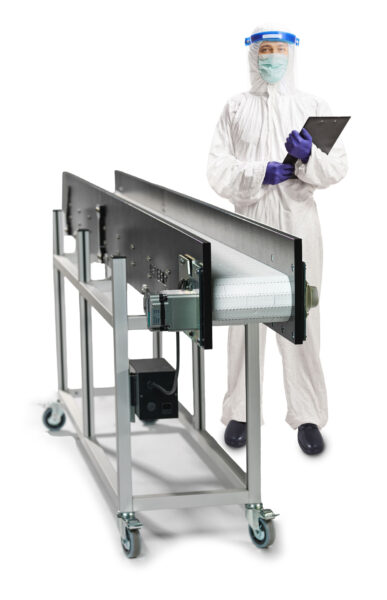 A Hybrid Clean room conveyor with a man in ppe gear standing next to it