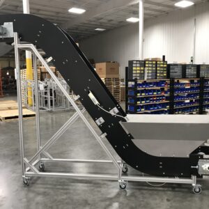 A metal detection conveyor with a hopper and an exist chute after just being assembled in a warehouse