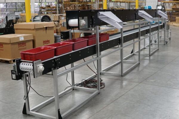 An over under conveyor with air blow off conveying plastic totes