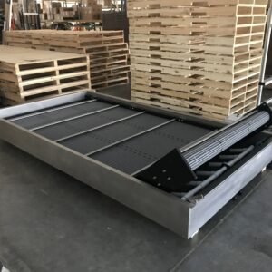 A Hybrid water bath conveyor with pallets in the background