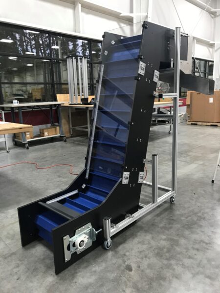 A Hybrid Z conveyor with dark blue belting and drive flights designed for heavy duty applications
