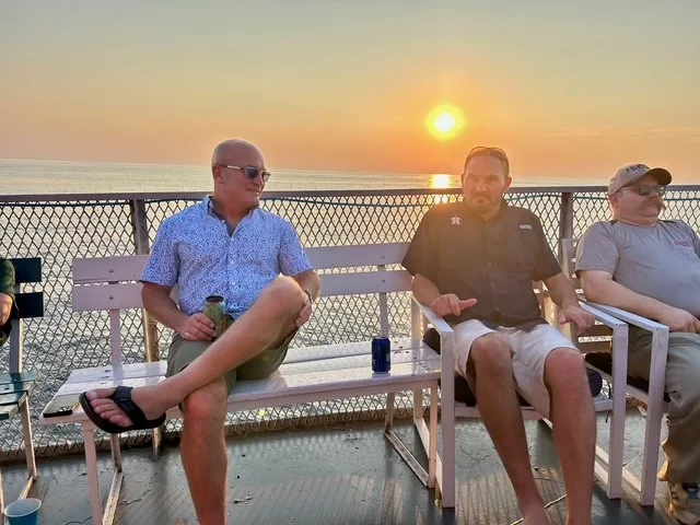 Dynamic Conveyor team members sitting on the deck of the sunset cruise boat