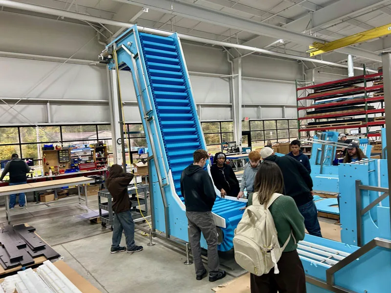 manufacturing week students learning aboute the design of the DynaClean Conveyor manufactured at Dynamic Conveyor