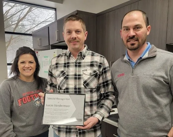 Lucas Vandermeer holding his employee recognition certificate