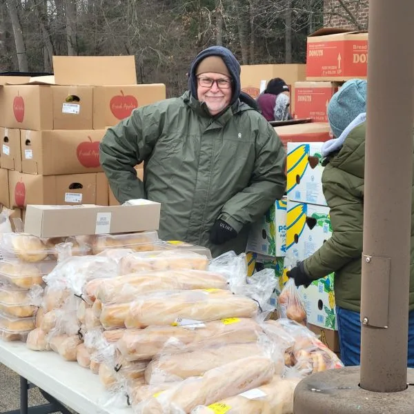 Dave-Rice-Feeding-America_2026 Dave Rice standing by piles of bread at Feeding America West Michigan event 2026 in Muskegon