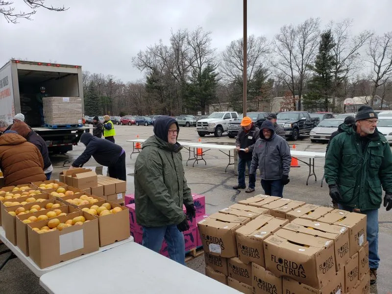 feeding-america-volunteers-2026-5 boxes of donated food and volunteers in parking log
