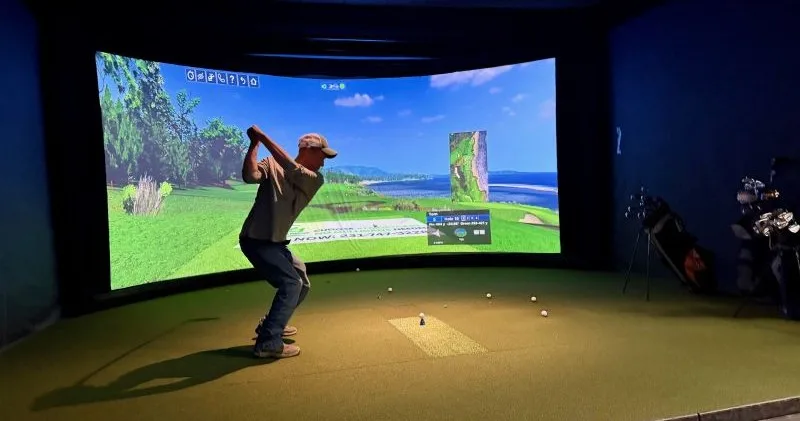 golf-simulator-swing Dynamic Conveyor team member taking a swing with a golf club