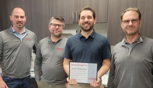 Scott Tiefenthal holding Q1 recognition certificate standing with Leaders of Dynamic Conveyor