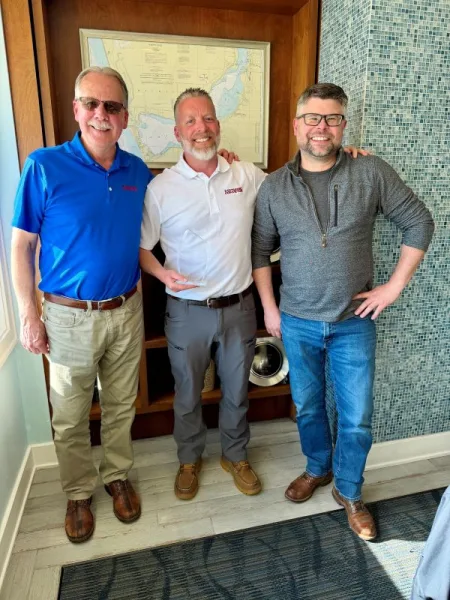 Tim DeVriendt and Chris Koopman from Dynamic Conveyor standing with Steve Holbrook of Rains Plastics