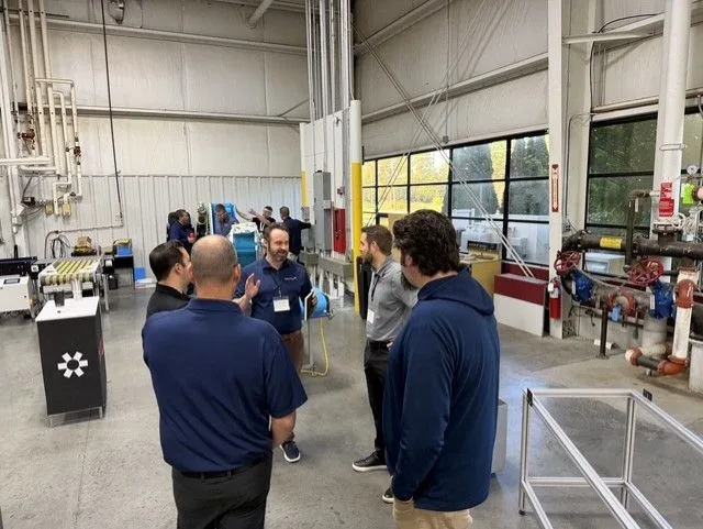 2026-DC-Partner-summit-5 partners and DC staff discussing conveyor innovation at facility